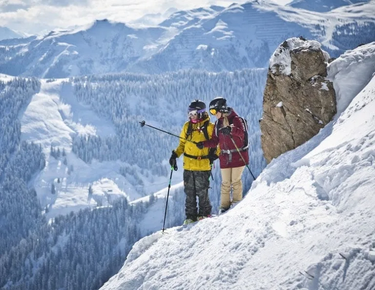 Skiopening Paar steht auf steilem Schneehang mit Skiern