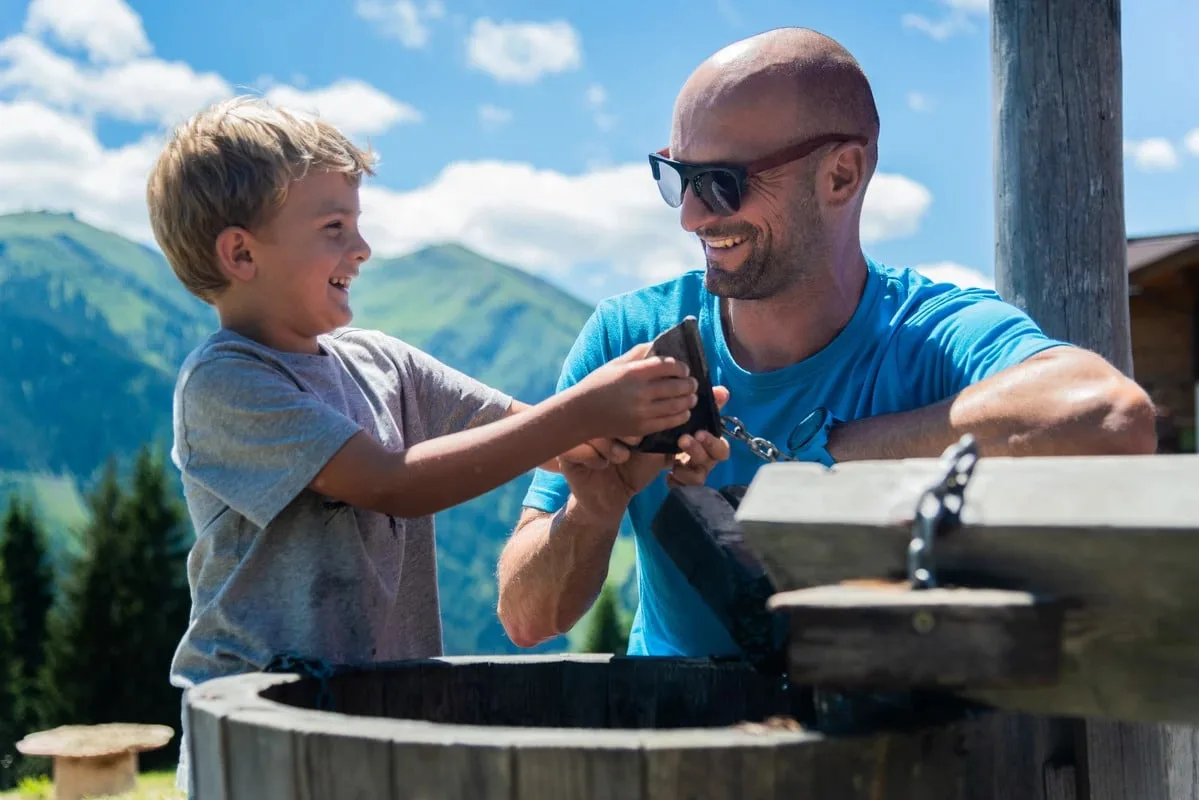 2925 Vater und Sohne blödeln bei Wasserspender herum