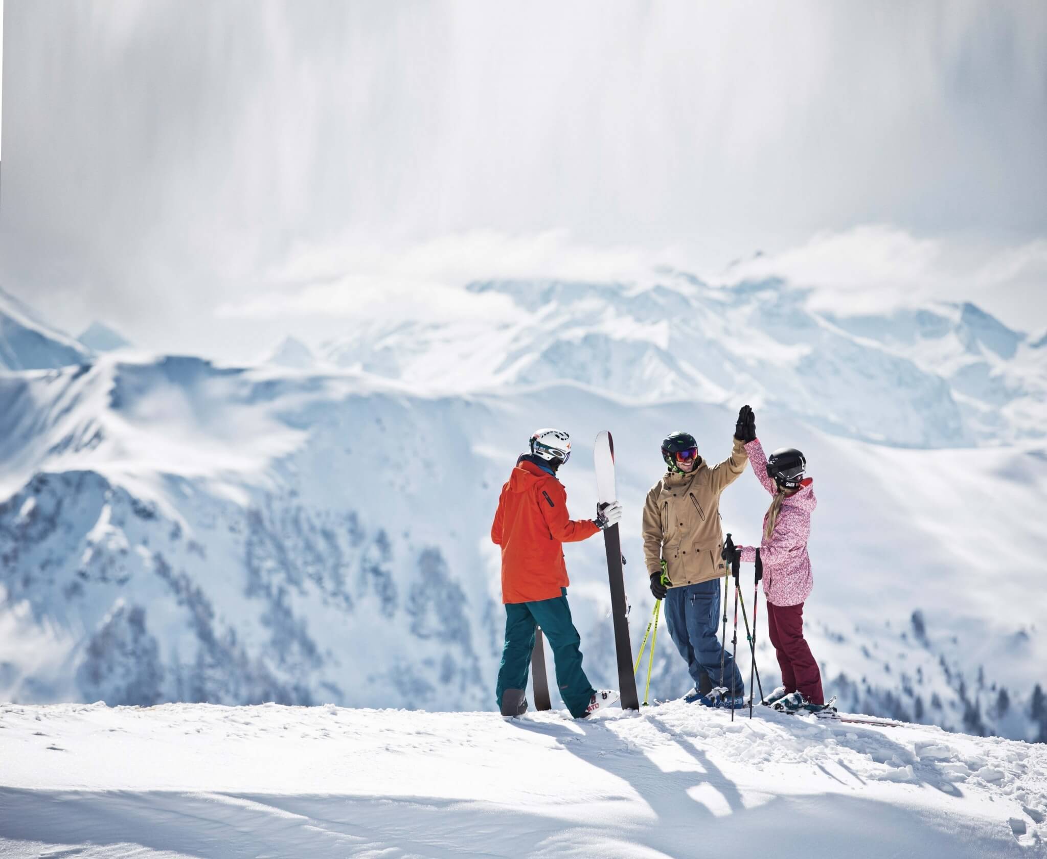 3 Skifahrer vor Bergpanorama