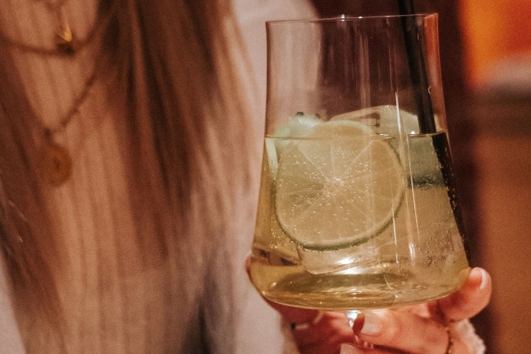 Limetten Drink in der Hand einer jungen Frau