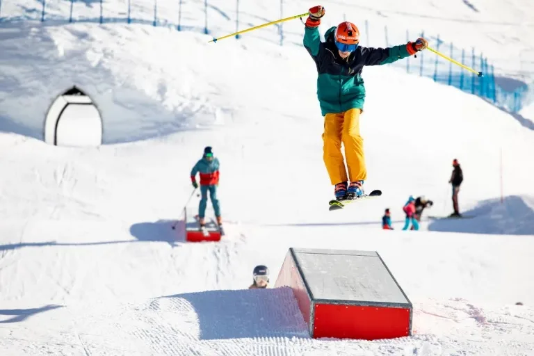 Winter Funslope Familypark Junger Skifahrer spring über Rampe