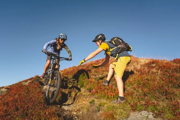 Glemmguides Hinterglemm Technik-Training Frau auf Fahrrad wird von Mann trainiert