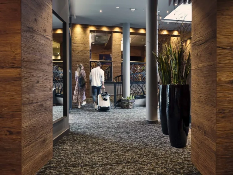 Hasenauer-So2021_047 Pärchen geht mit seinem Koffer durch das Hotel Hasenauer