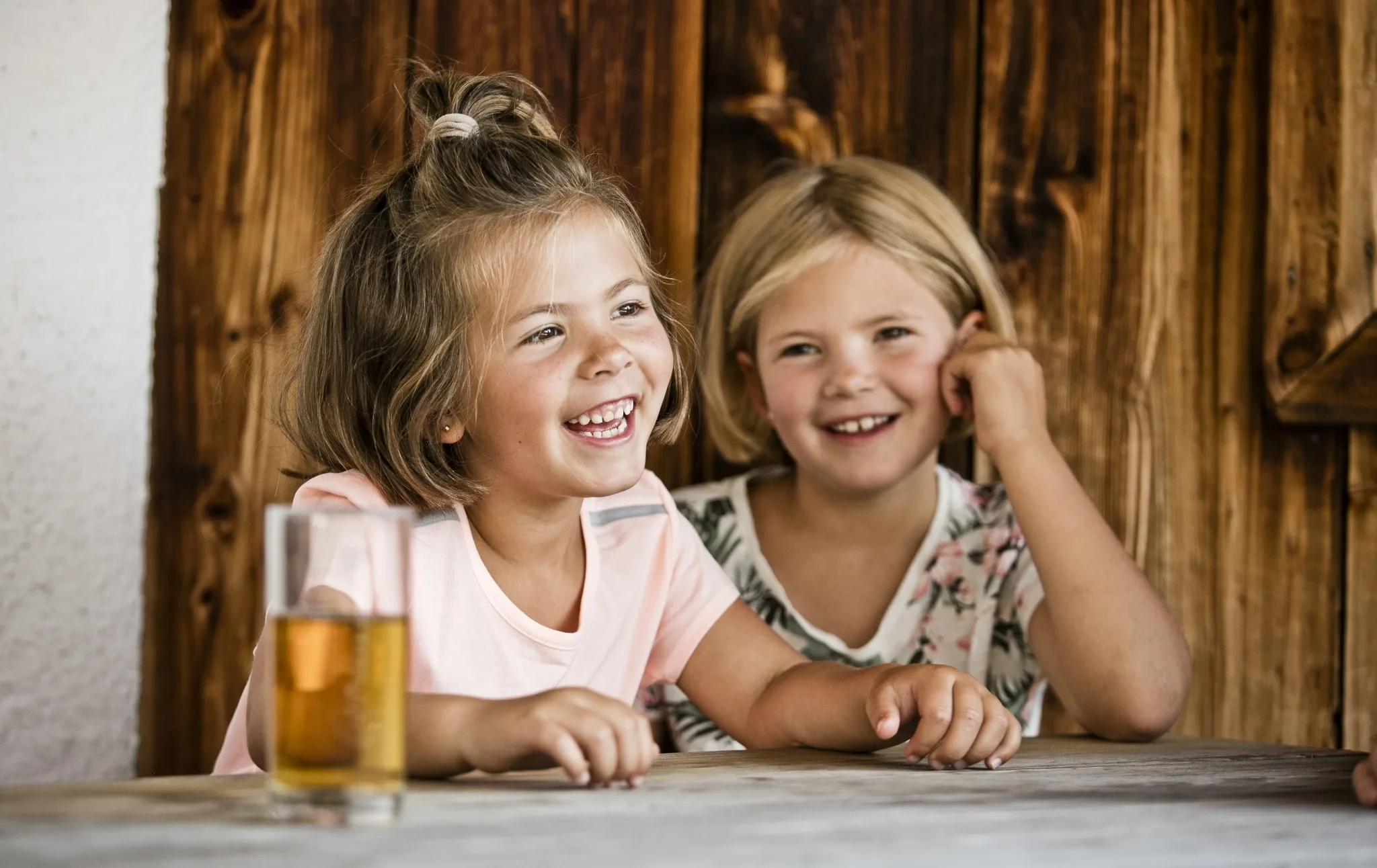 4857 2 Mädchen sitzen lachend an Tisch