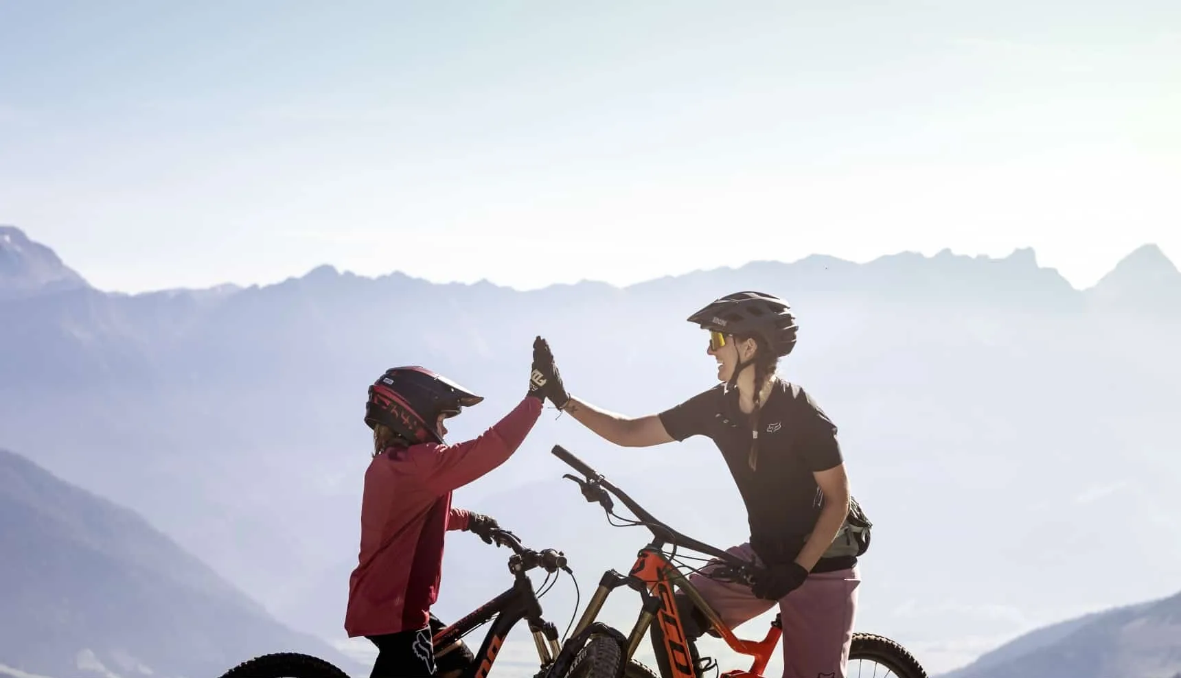 4873 Mutter und Kind auf Fahrrädern geben sich High-Five