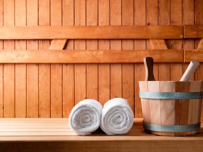 Sauna aus Holz mit Handtüchern und Kübel