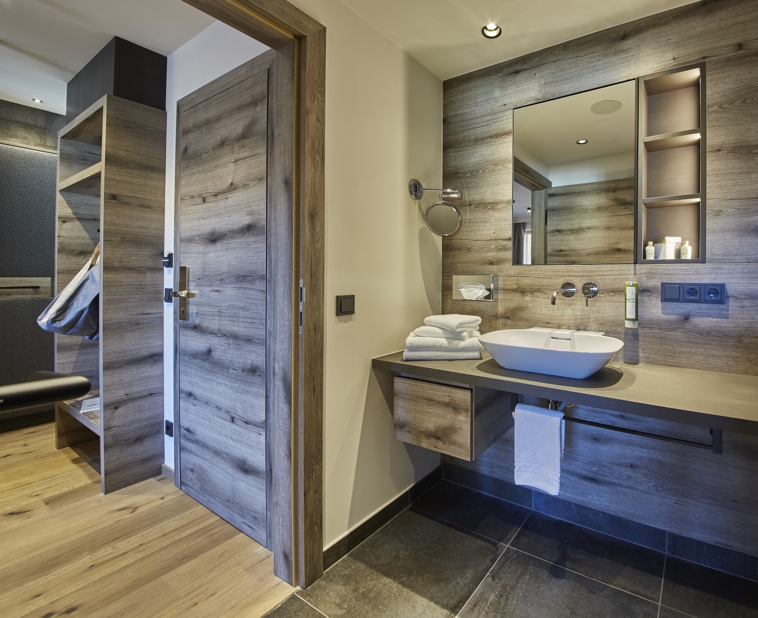 Das Badezimmer im Studio Hochtor mit Holzablagen und weißen Waschbekcen