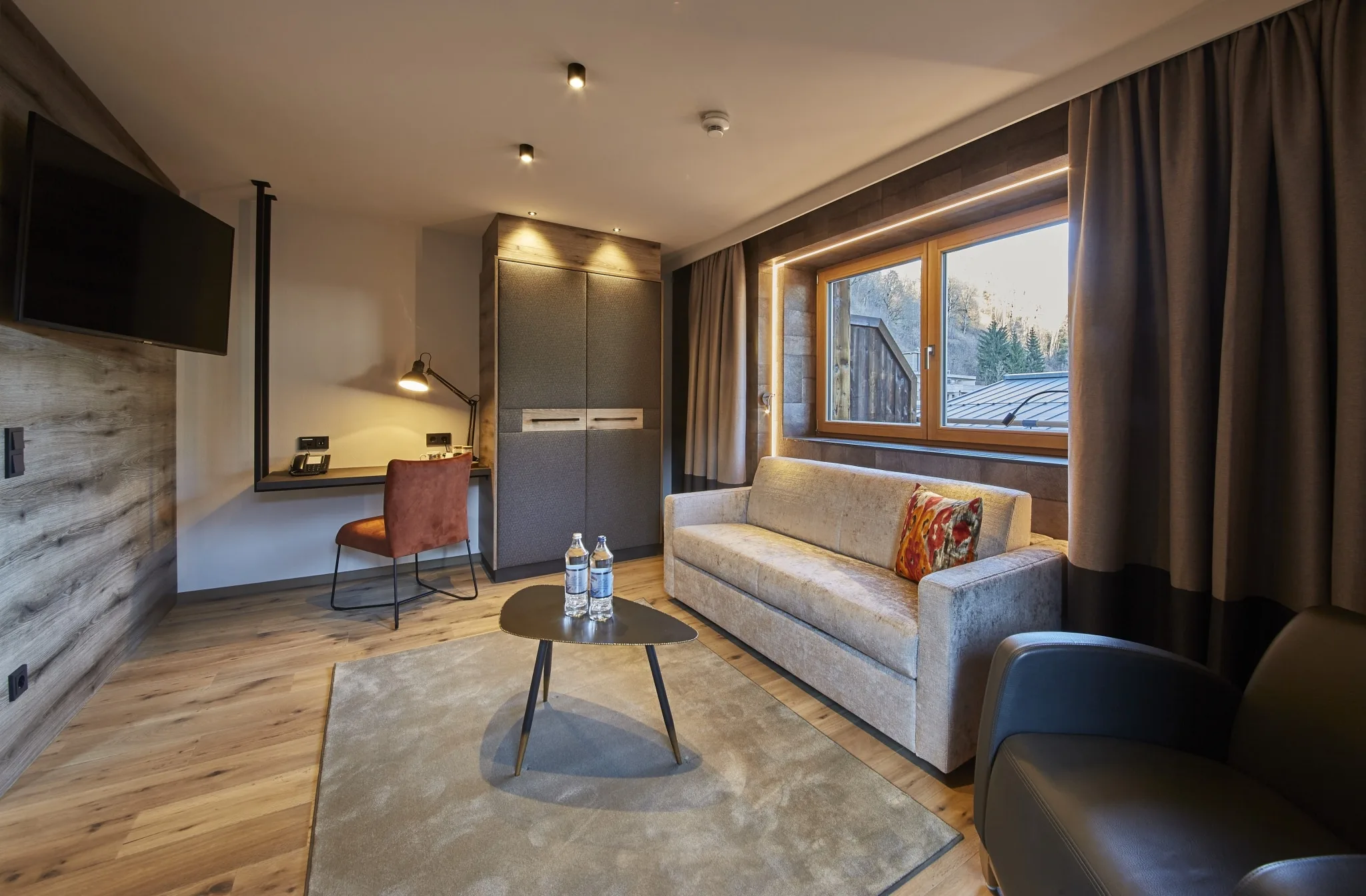5678 Studio Reiterkogel Wohnzimmer mit Sofa und Schreibtisch