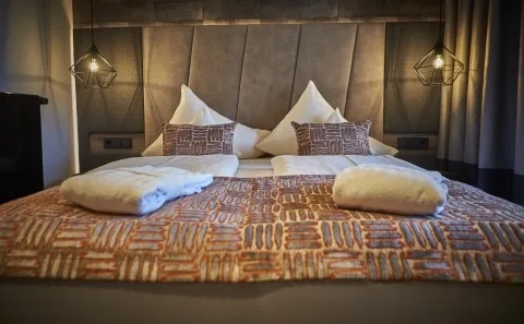 Doppelbett mit Tagesdecke Doppelbett mit Polstern, Tagesdecke und Bademänteln