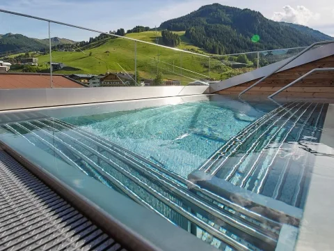 Whirlpool auf der Sonnenterrasse Die Bergwelt im Hintergrund und der Rooftop-Whirlpool im Vordergrund