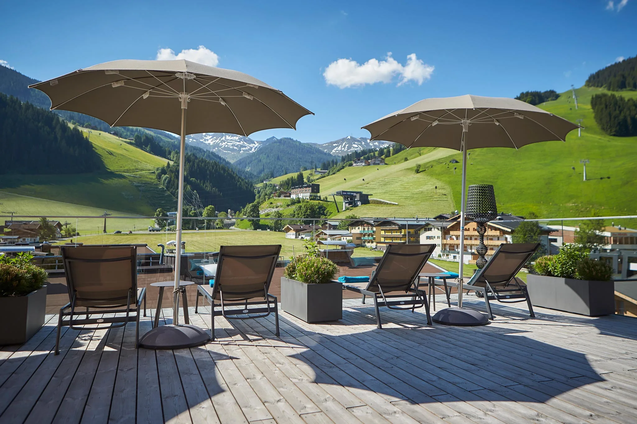 Sonnenschirme, Sonnenliegen und einen tolle Aussicht auf die umliegende Bergwelt