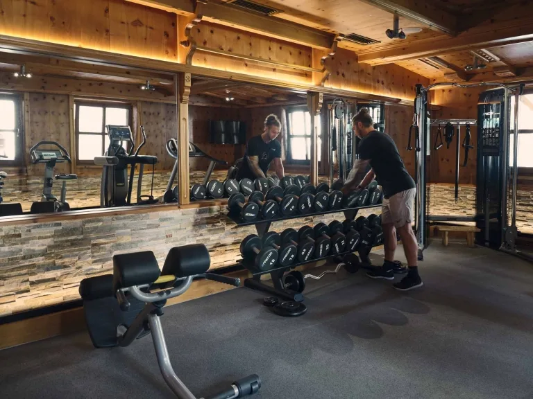 Gewichtewand im Fitnessraum Man trainiert mit Handgewichten