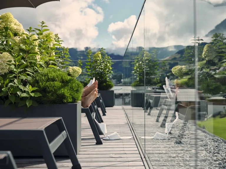 Entspanntes chillen auf dem Rooftop Füße von zwei Personen auf einem Liegestuhl auf der Dachterrasse