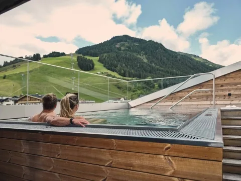 Whirlpool mit Aussicht Zwei Personen im Rooftop-Whirlpool schauen in die Landschaft