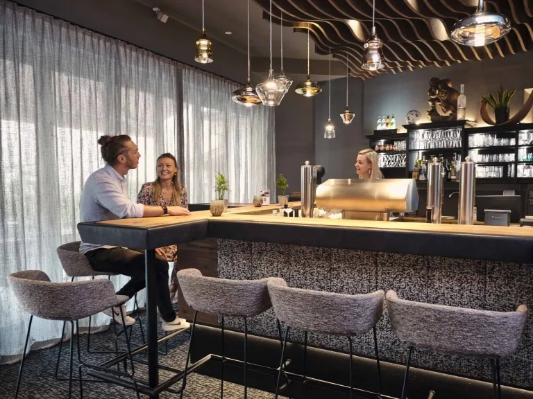 Hotelbar im Hasenauer Zwei Personen sitzen an der Hotelbar und reden mit der Barfrau