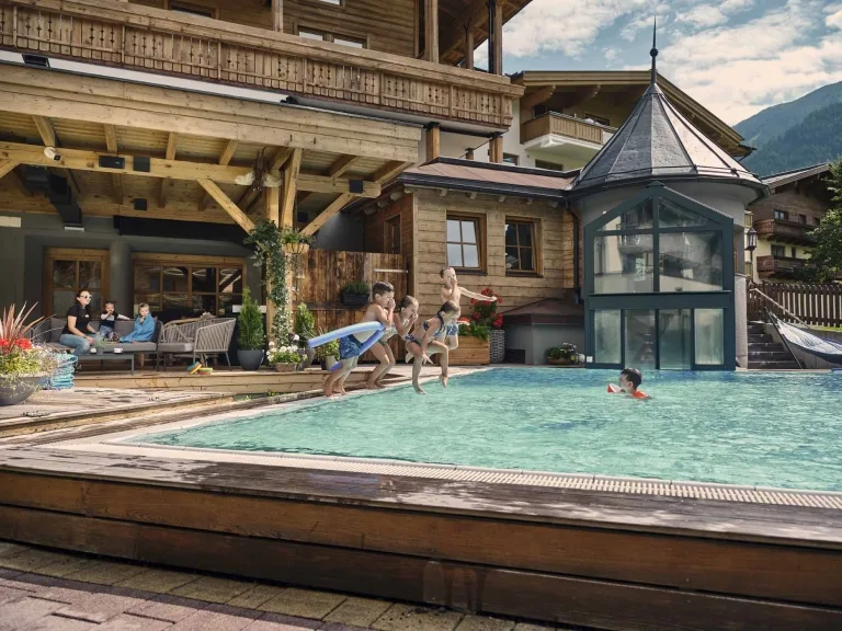 Wasserspaß für Kids Kinder springen gemeinsam in den Außenpool