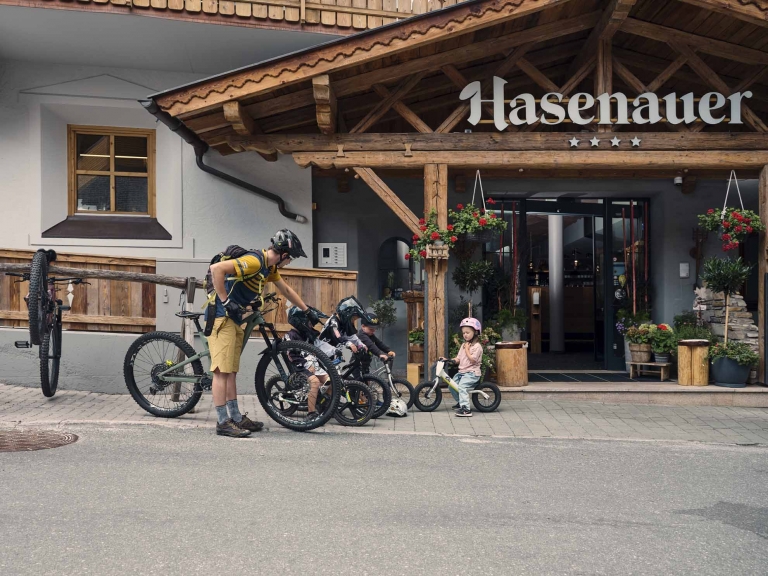Kinder am Bike und ein erwachsener Biker stehen vor dem Hotel Hasenauer