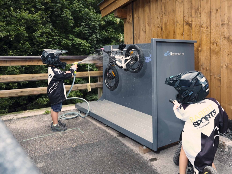 Kinder waschen das Bike am Bike-Waschplatz