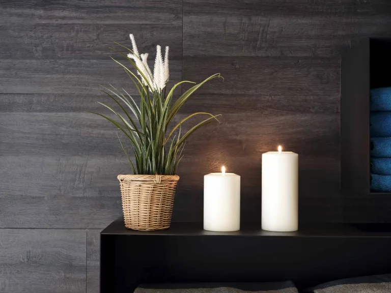 Dekoration im Hasenauer SPA Zwei Kerzen und eine Dekorations-Blume auf einem schwarzen Untergrund