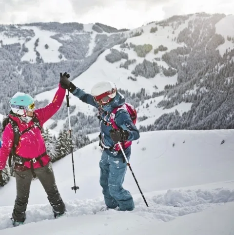 Skifahrer-Team Drei Skifahrer stehen auf der Piste und zwei klatschen sich gegenseitig ein