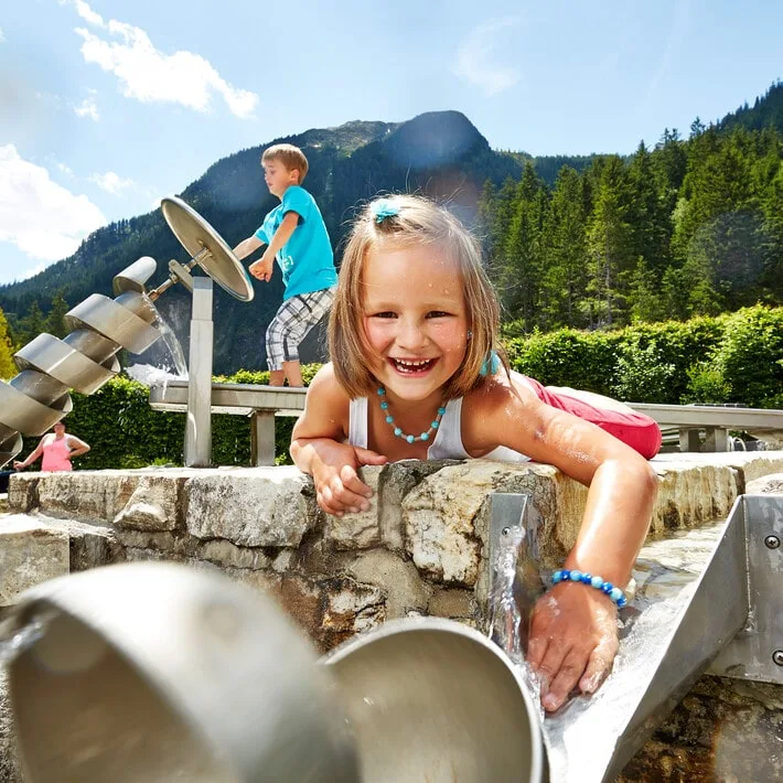 saalbach-wasserfalle-krimml-2 Zwei Kindern spielen mit Wasserspielen