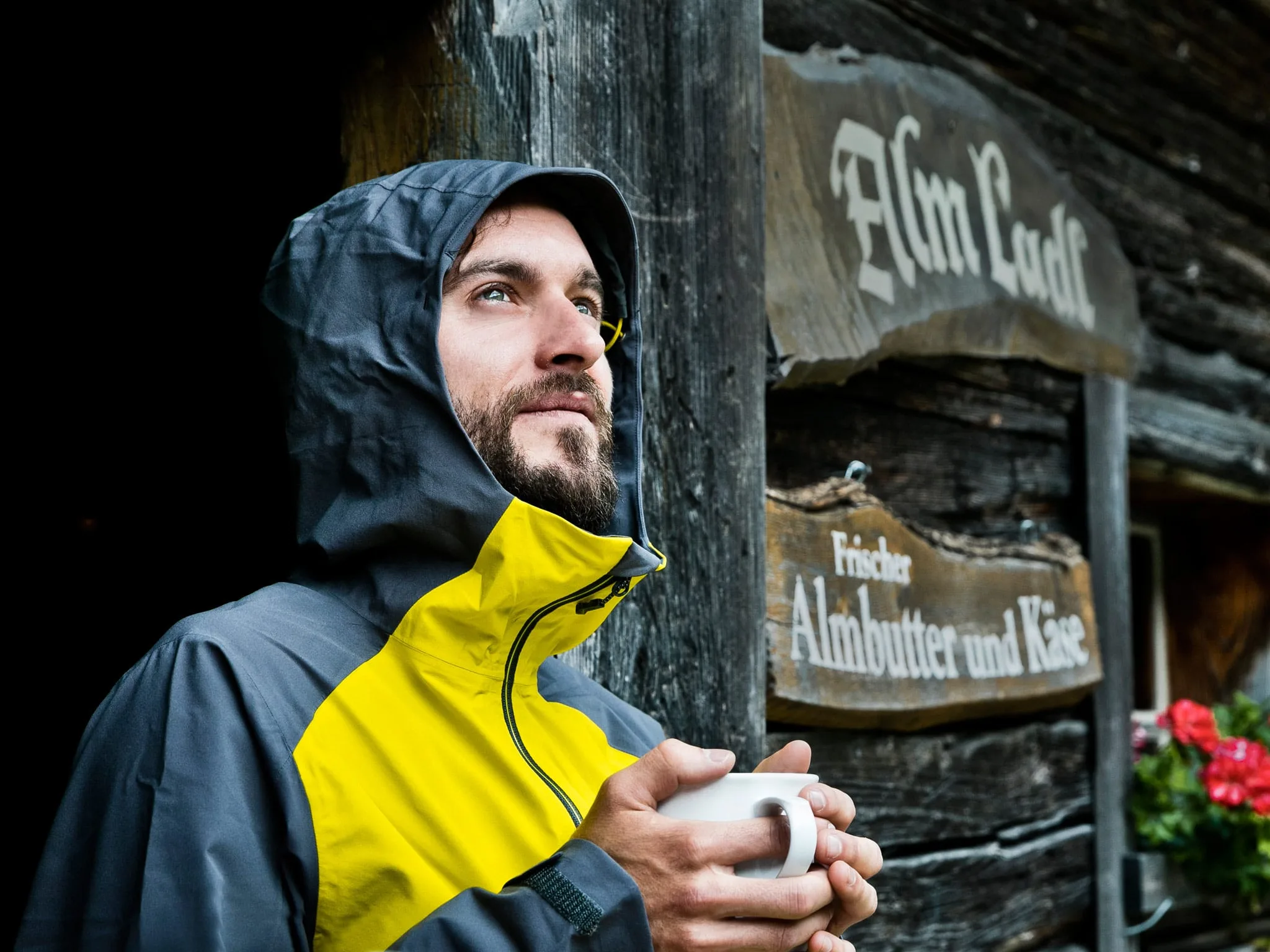 Mann mit Tasse in der Hand Ein Mann mit Regenjacke hält eine Tasse in der Hand