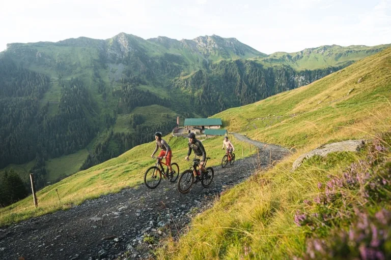 Bike-Touren in Saalbach Hinterglemm 3 Personen biken auf einer Schotterstraße nach oben