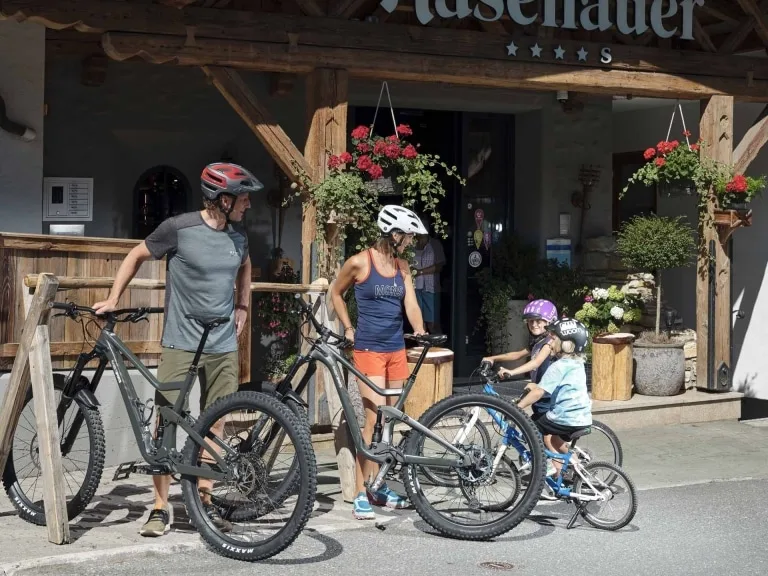 Familienspaß vor der Bike-Tour Eltern lachen die Kinder an bevor es zur Biketour geht.