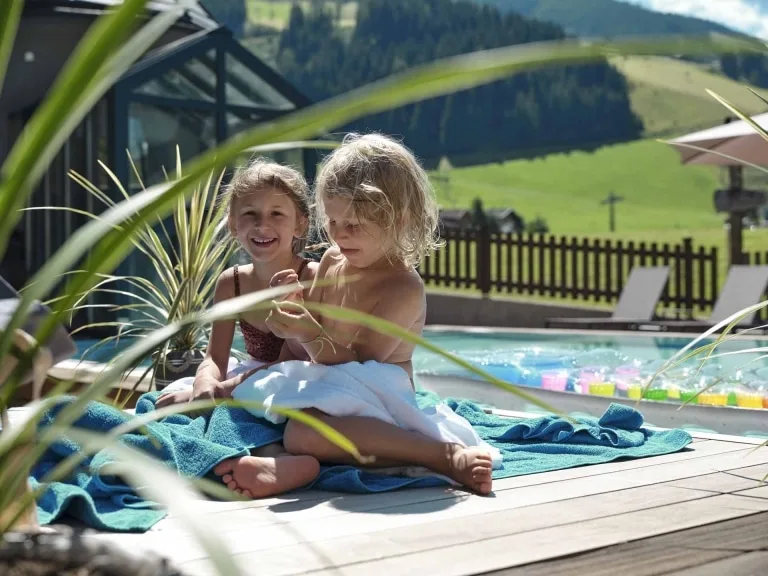 Kinderspaß auf der Terrasse Kinder sonnen sich neben dem Pool.