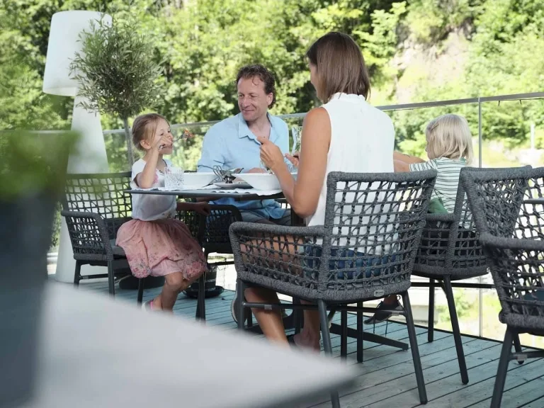 Mittagessen auf der Terrasse Familie sitzt auf der Terrasse beim Mittagessen