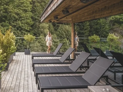 Hasenauer Hotel by Wealthyadventure_5222 Dame steht auf Terrasse und blickt in die Natur