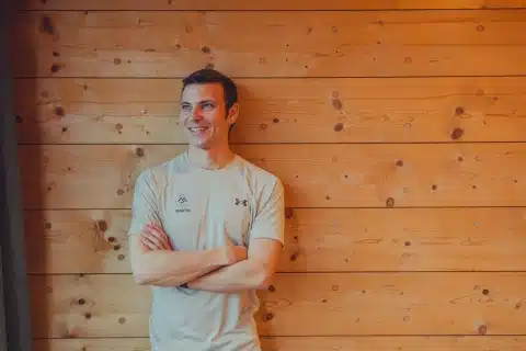 DSC07470 Herr mit grauem T-Shirt vor Holzwand