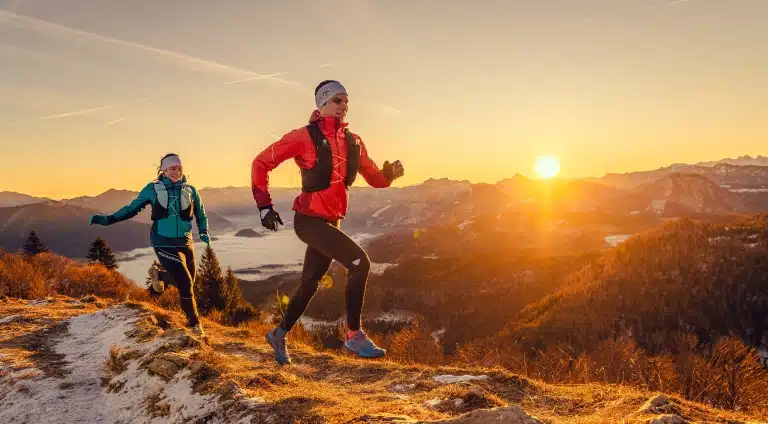 2 Personen beim Trailrunning auf Berg mit Sonnenaufgang