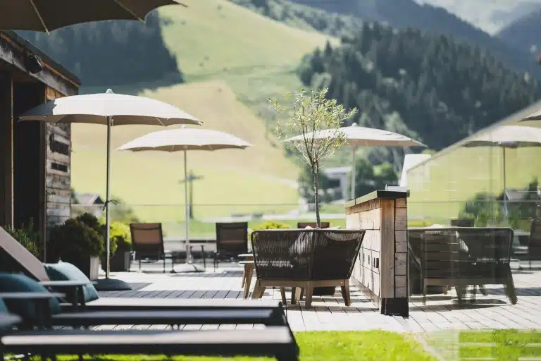 HOTEL HASENAUER Mehrere Schirme und Liegen auf Terrasse